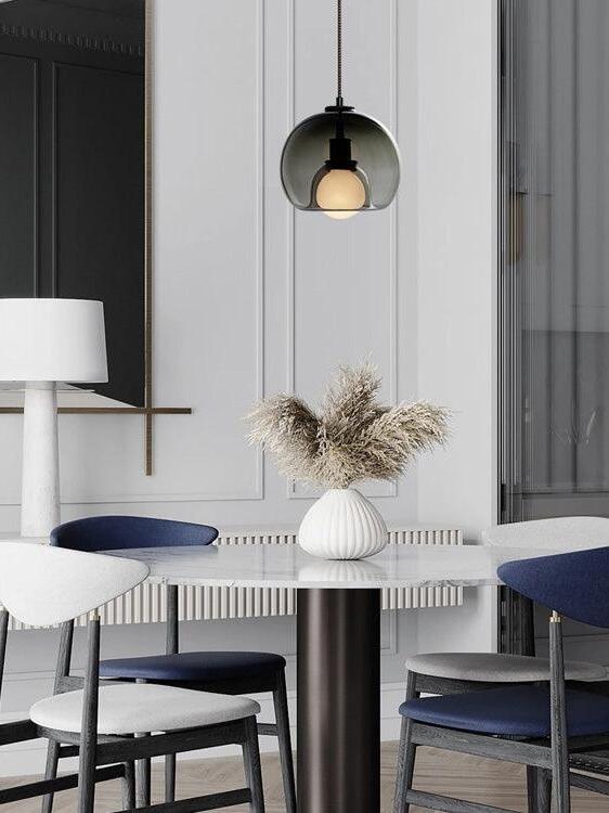 Smoke-toned Eres glass pendant in a monochrome dining room.