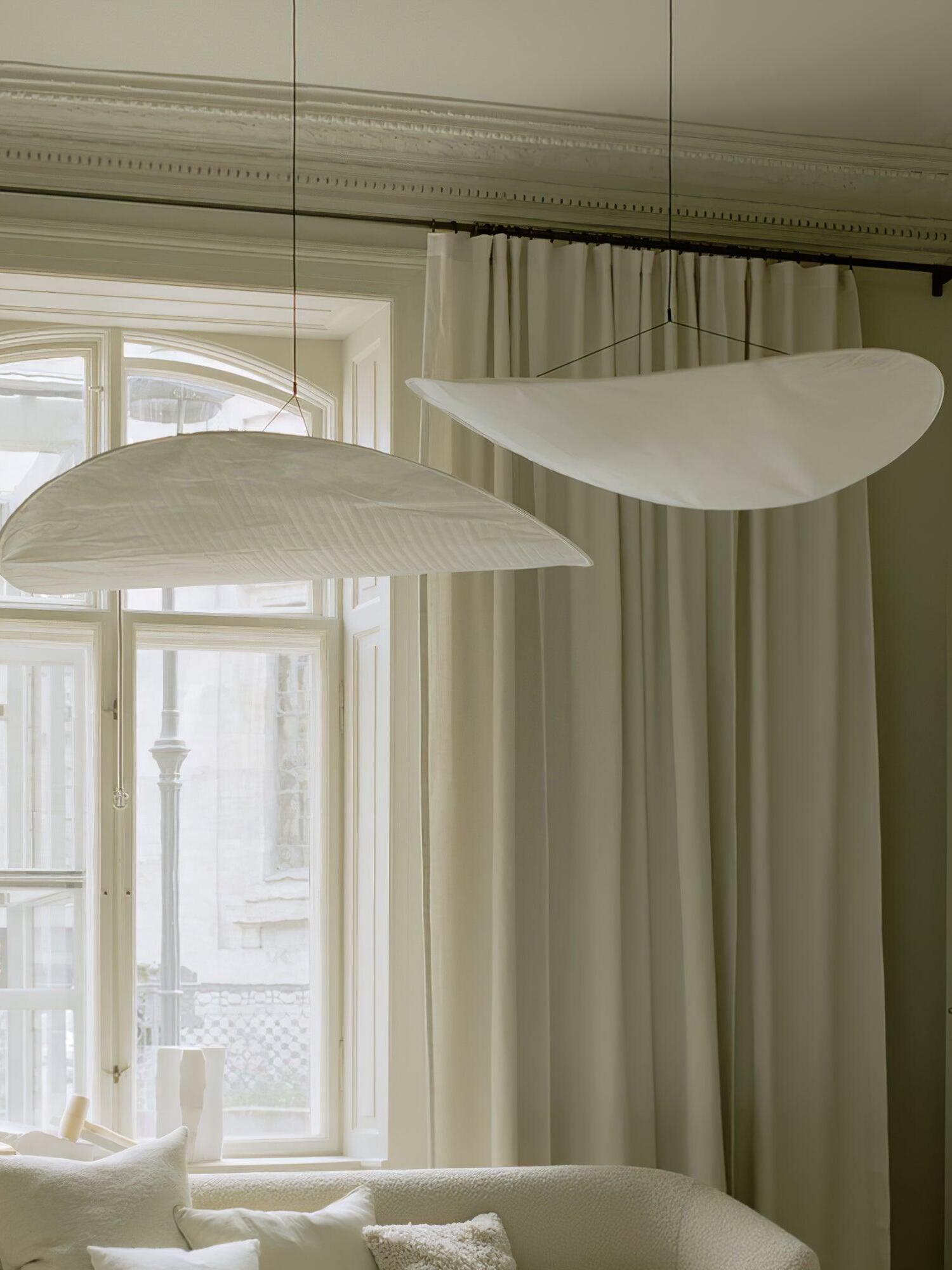 Two white shades beside tall windows and curtains