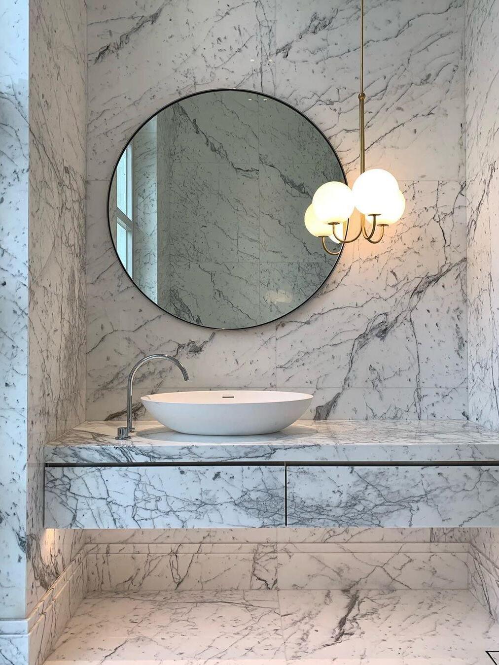 Three-globe pendant in a marble bathroom scene