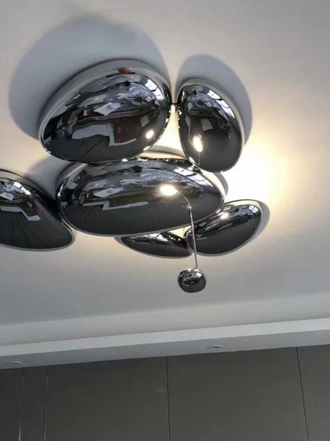 Reflective cluster with five visible large pebble forms and smaller suspended oval