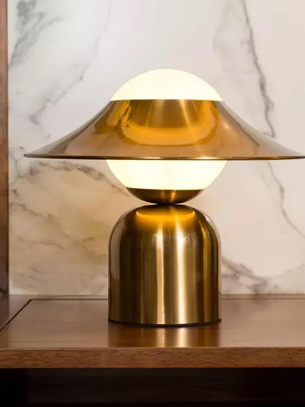 Lit glass globe and gold ring against patterned wall