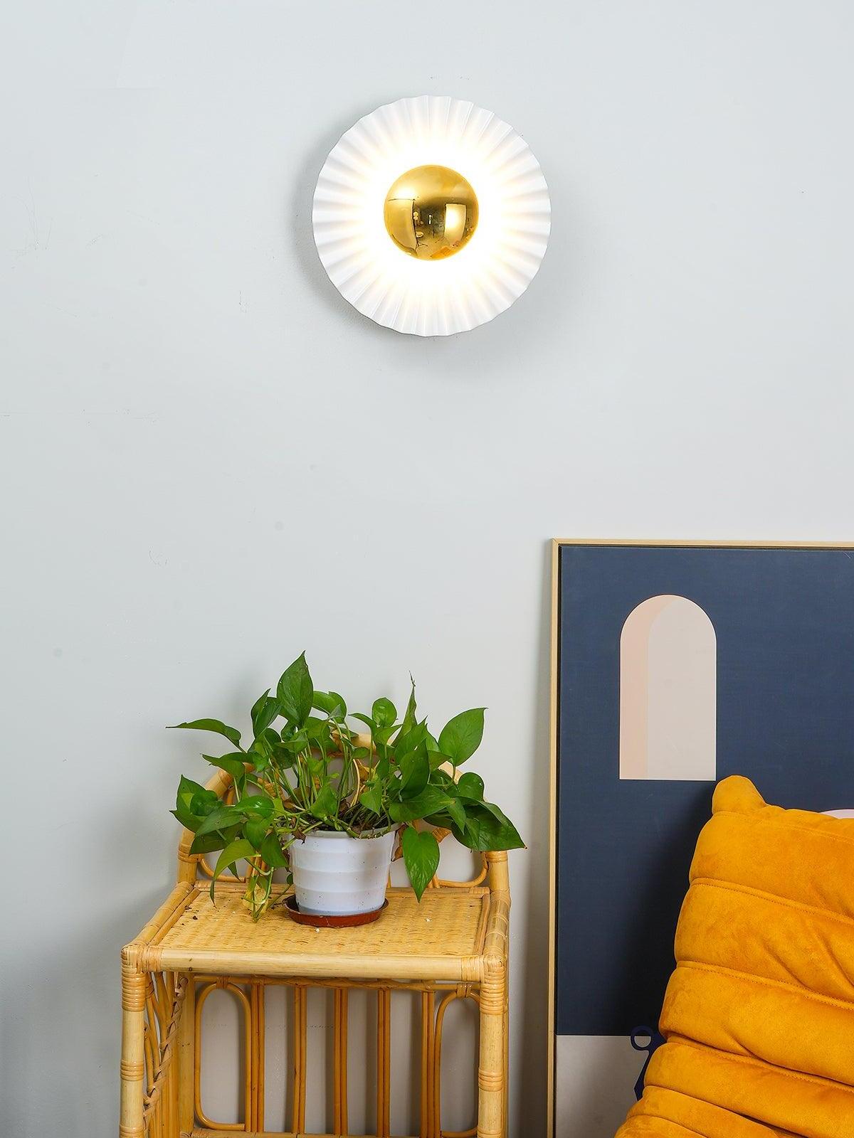 Glowing white and gold wall light above side table