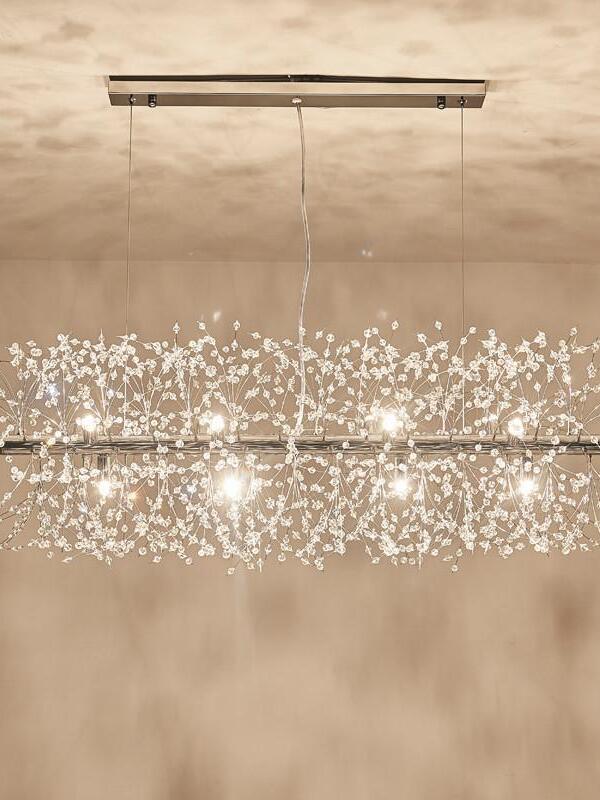 Linear glass-bead chandelier casting branching shadows on a textured wall