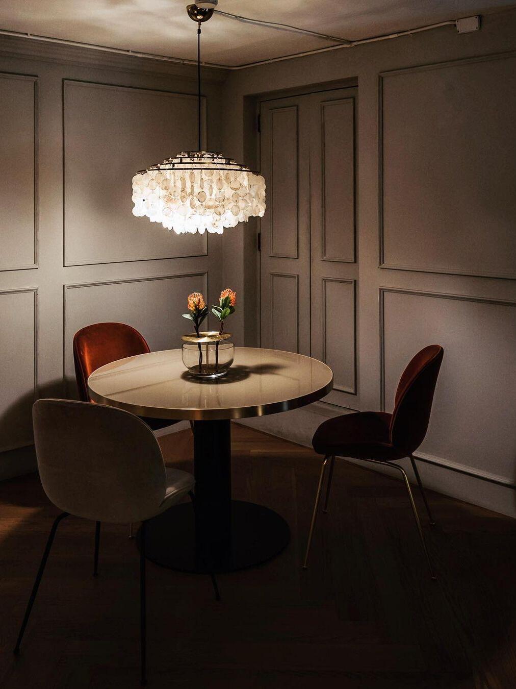 Round shell fixture above a small dining table