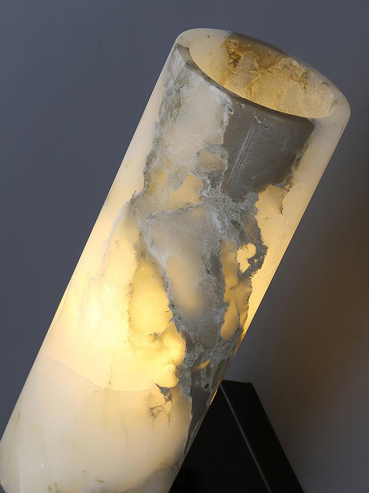 Close angled detail of lit veined marble cylinder