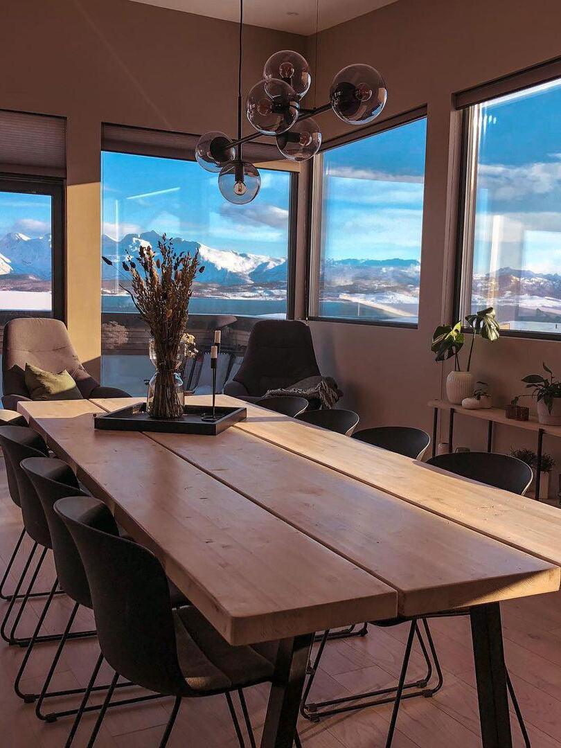 Globe chandelier over a table beside a large window