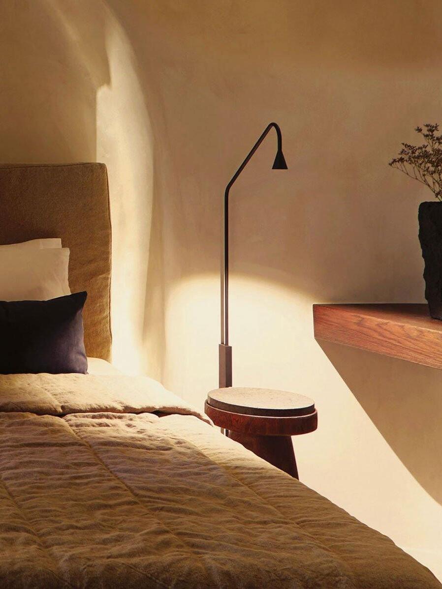 Black sconce above a round bedside table