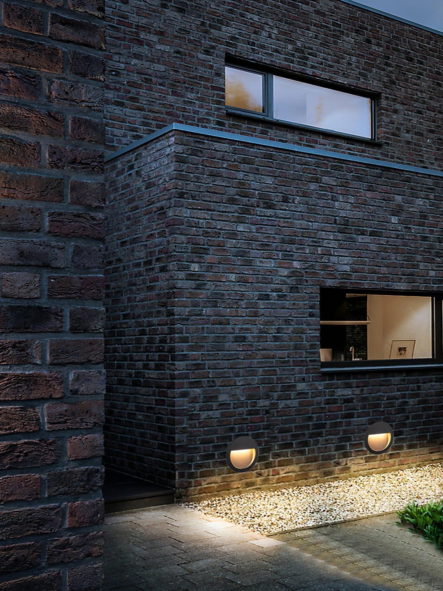 Two low lights by brick building and path