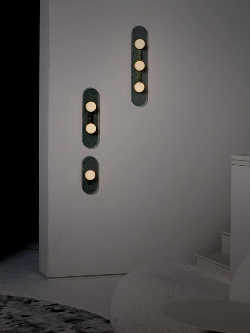 Glowing Modulo domes on a dimly lit stair wall with several vertical glass panels