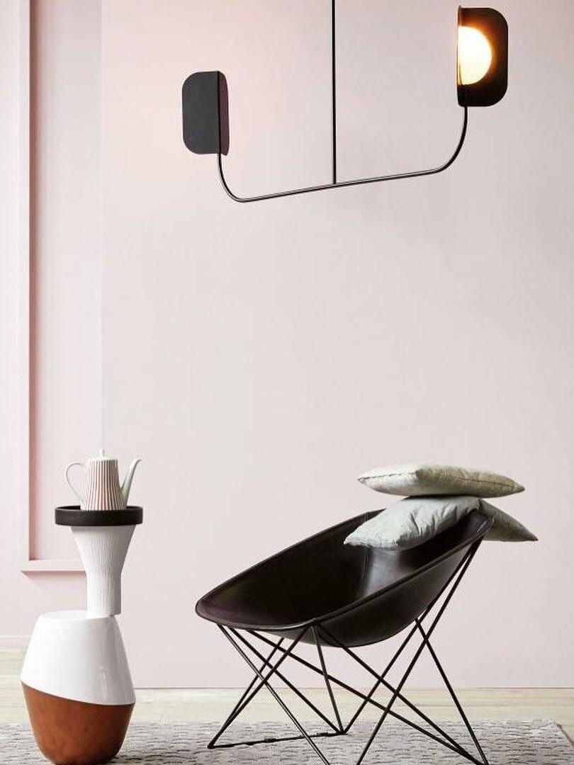 Black leaf-shield fixture near a modern chair