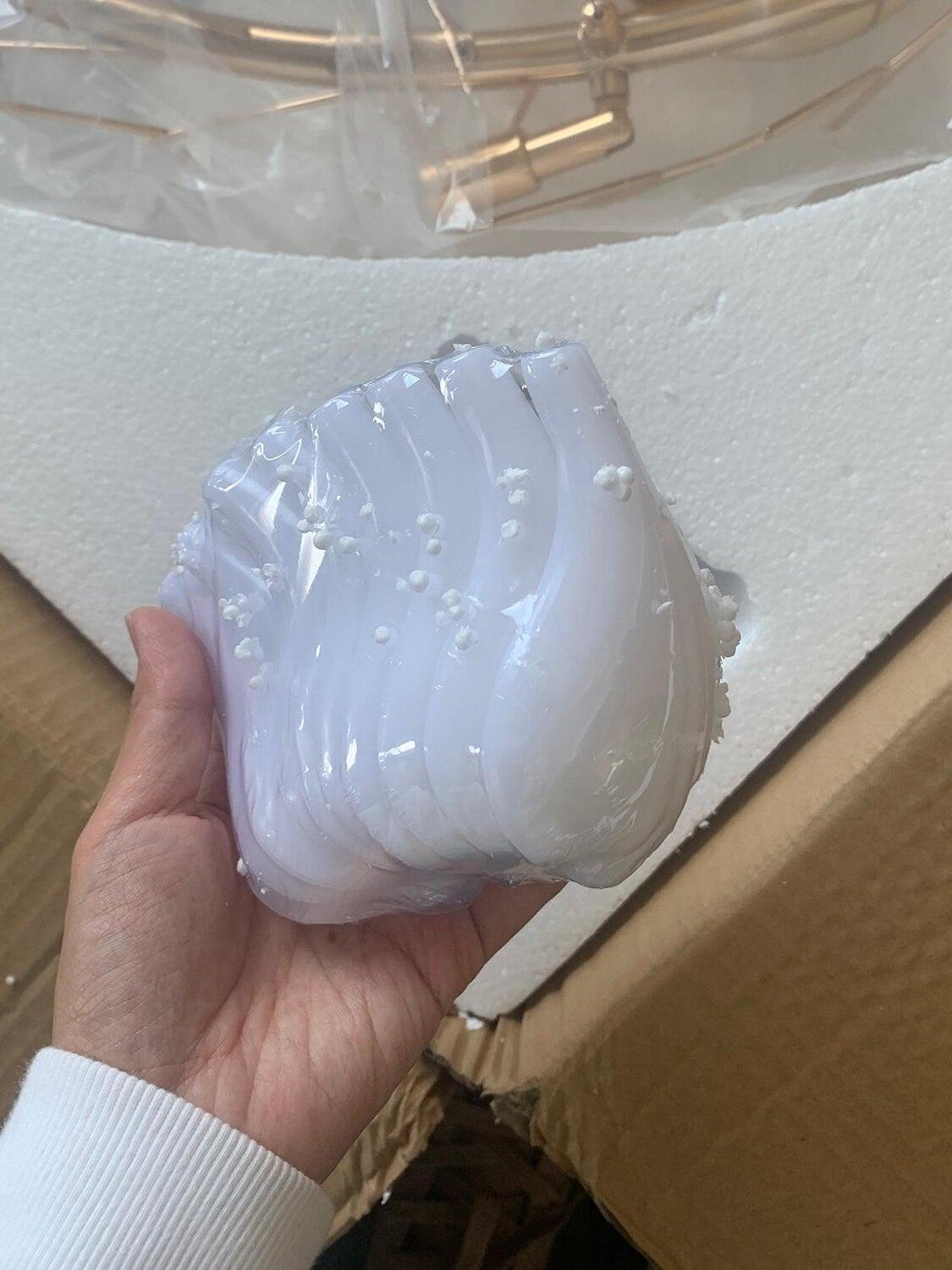 Wrapped white leaf component held above the packing box