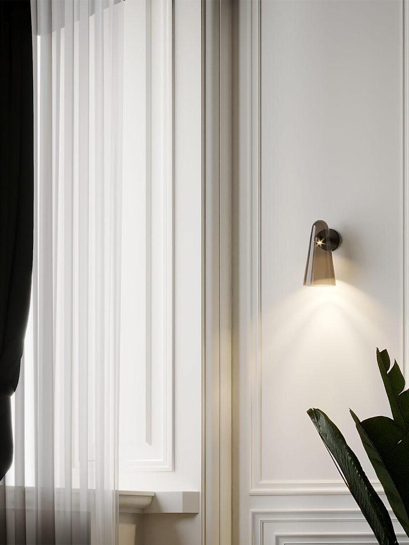 Conical wall fixture beside curtains and plants