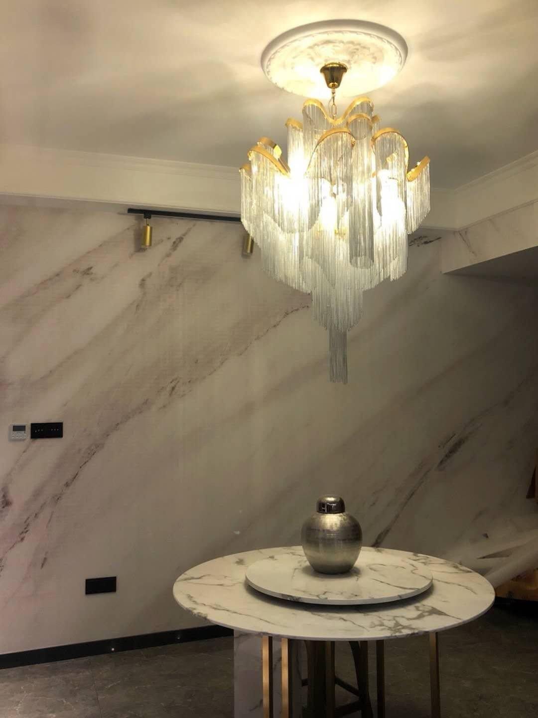 Glowing tiered chain chandelier over a round table