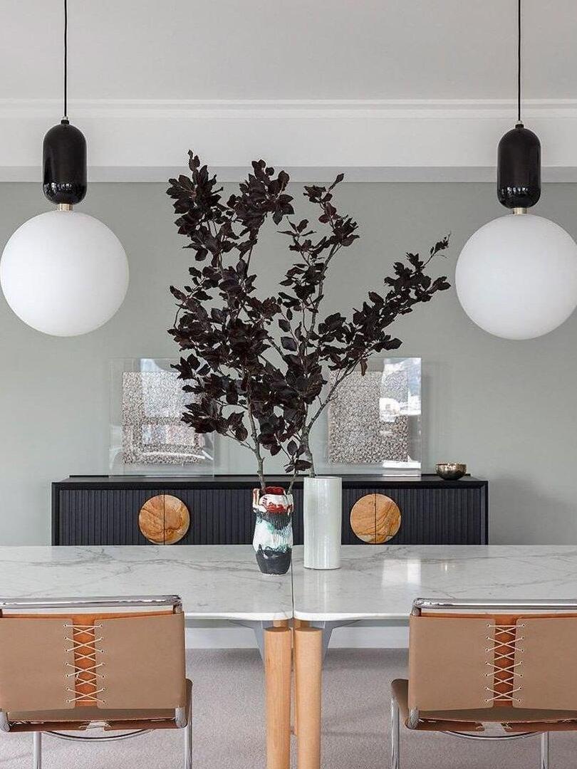 Two black-cap globe pendants above a table
