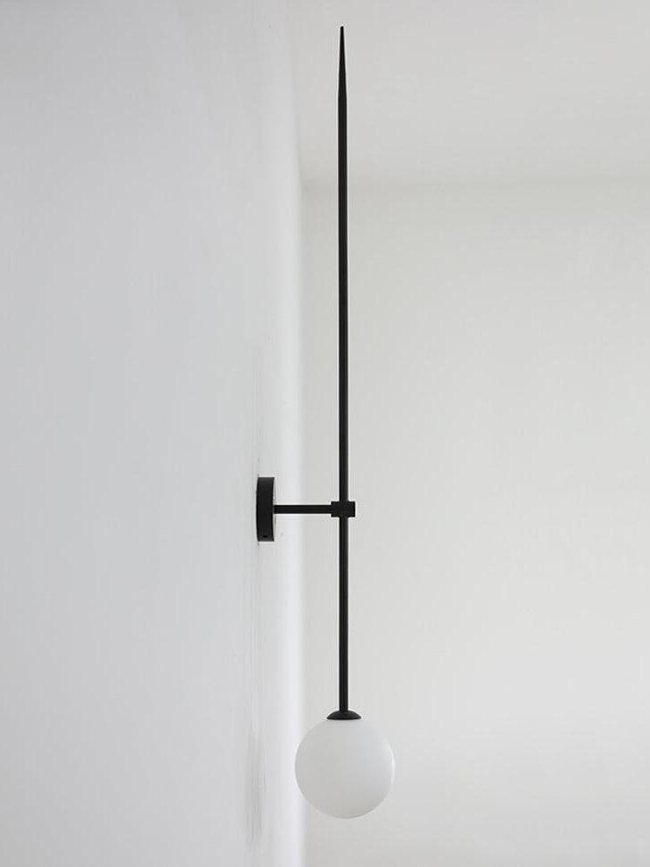 Unlit black rod wall light in side view, with a short arm separating the rod from its round backplate
