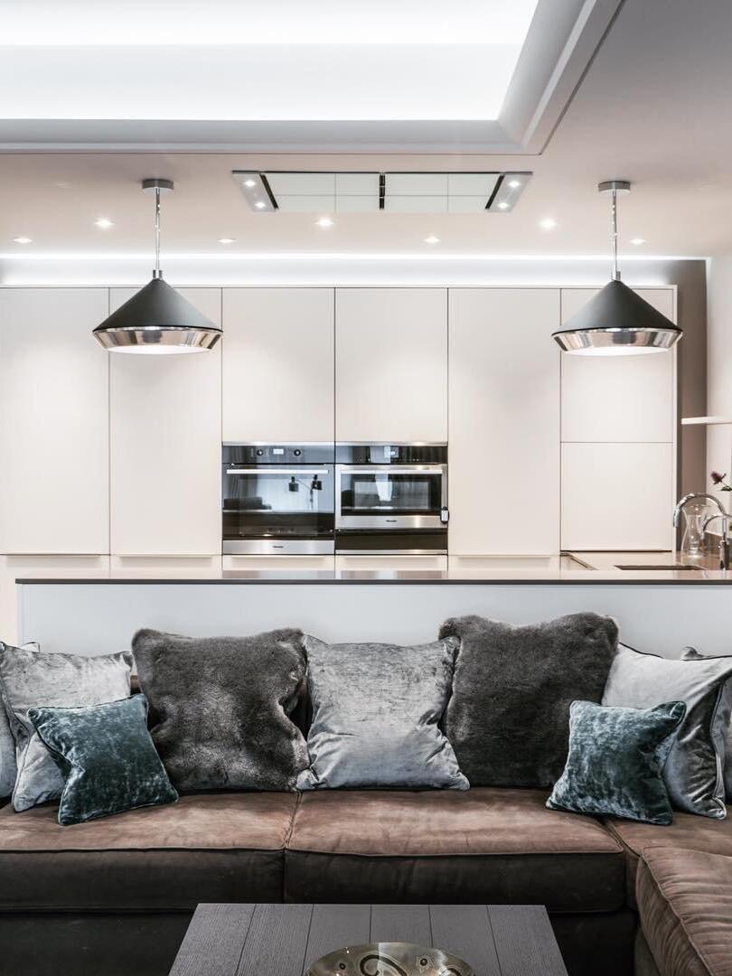 Shear pendants visible behind a living-room sofa
