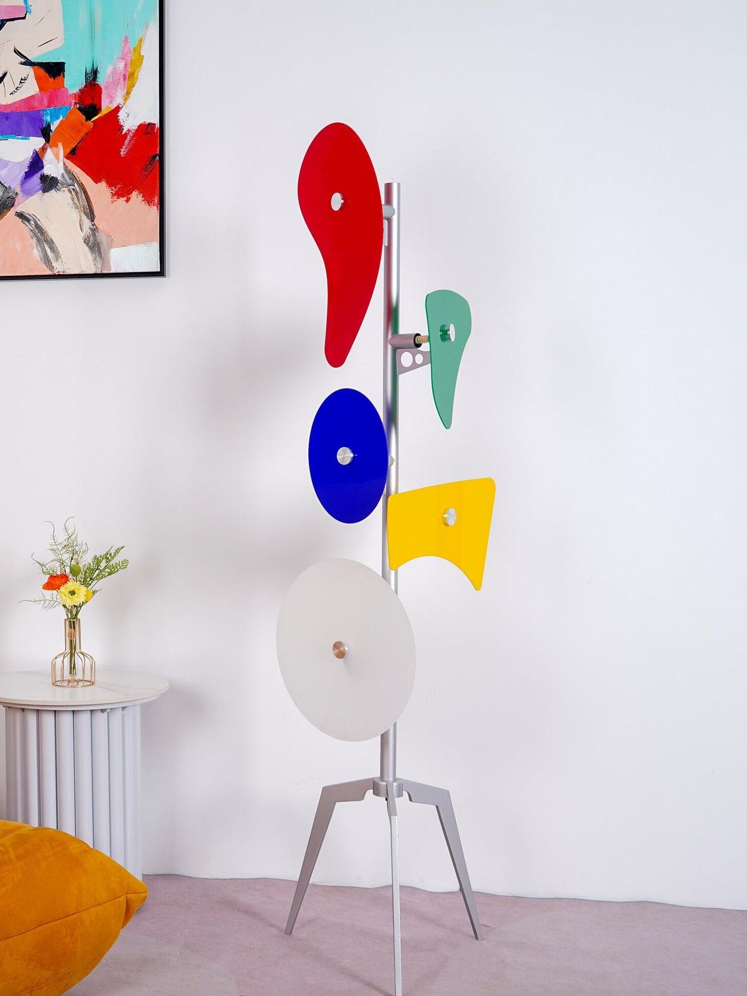 Multicolour floor lamp beside wall art