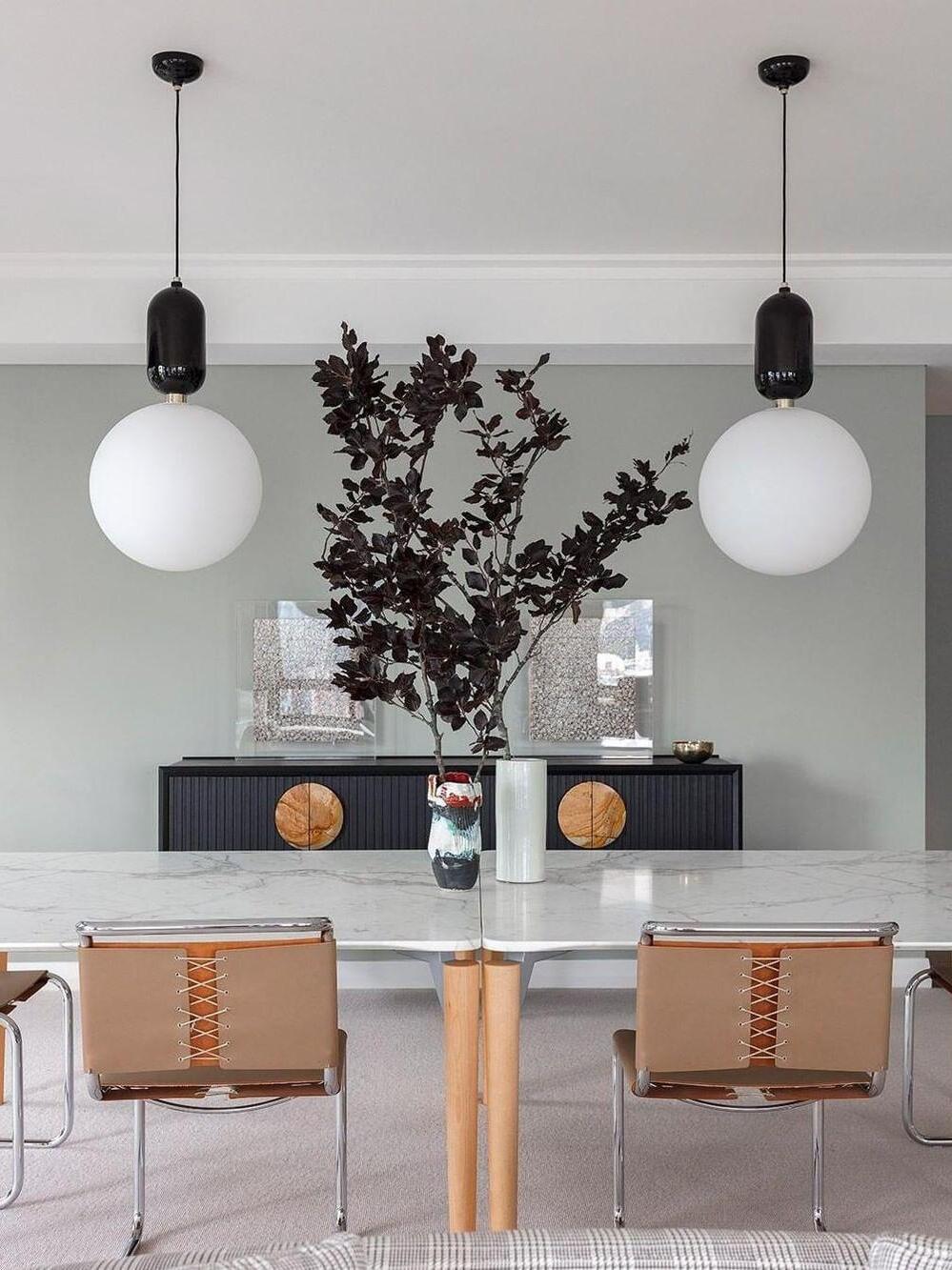 Two black-cap white globes above a table and chairs