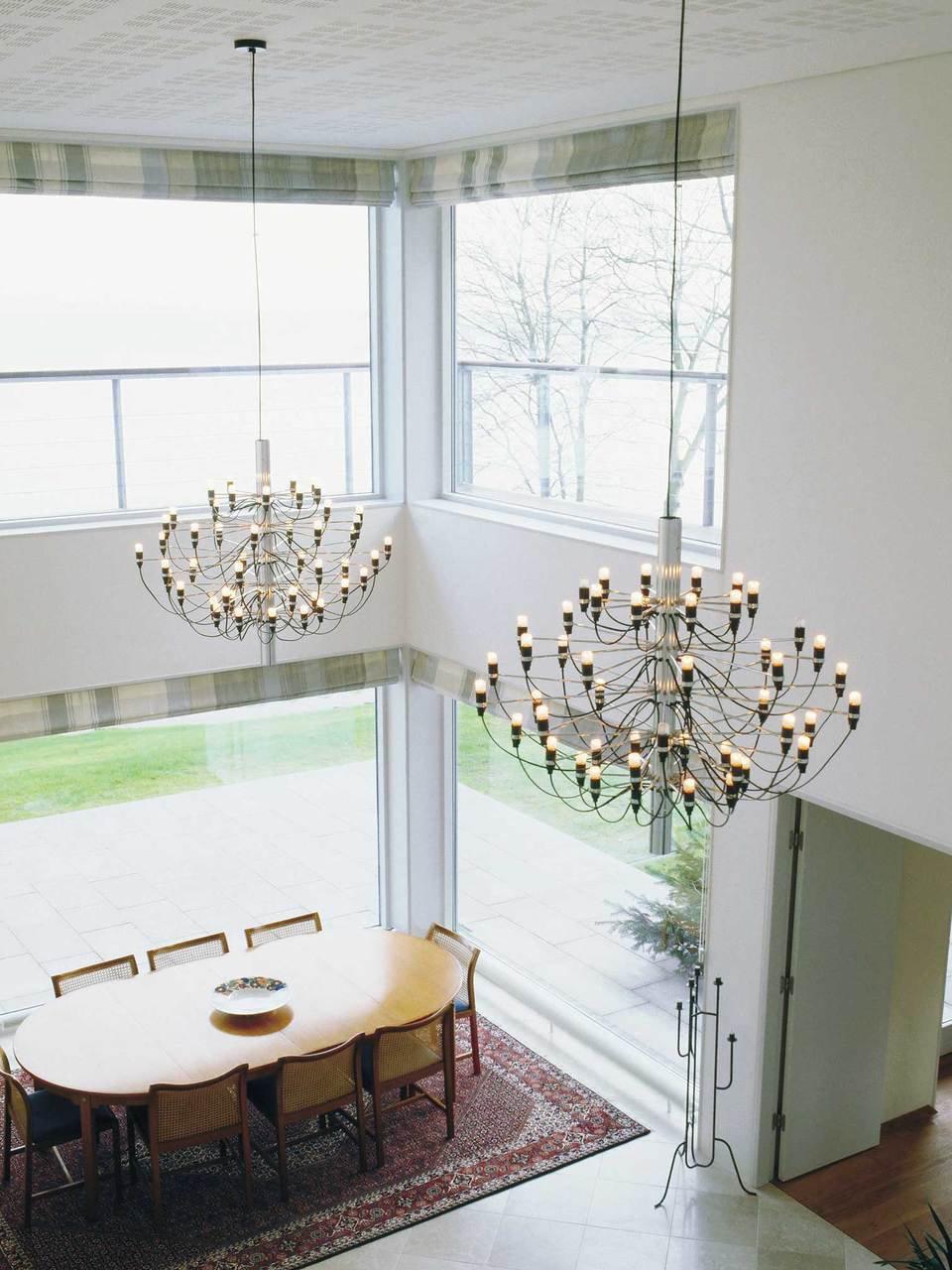 Two chandeliers in a double-height dining space