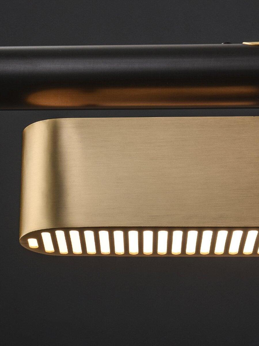 Macro view of a rounded Colt brass housing and illuminated slots below the black rail