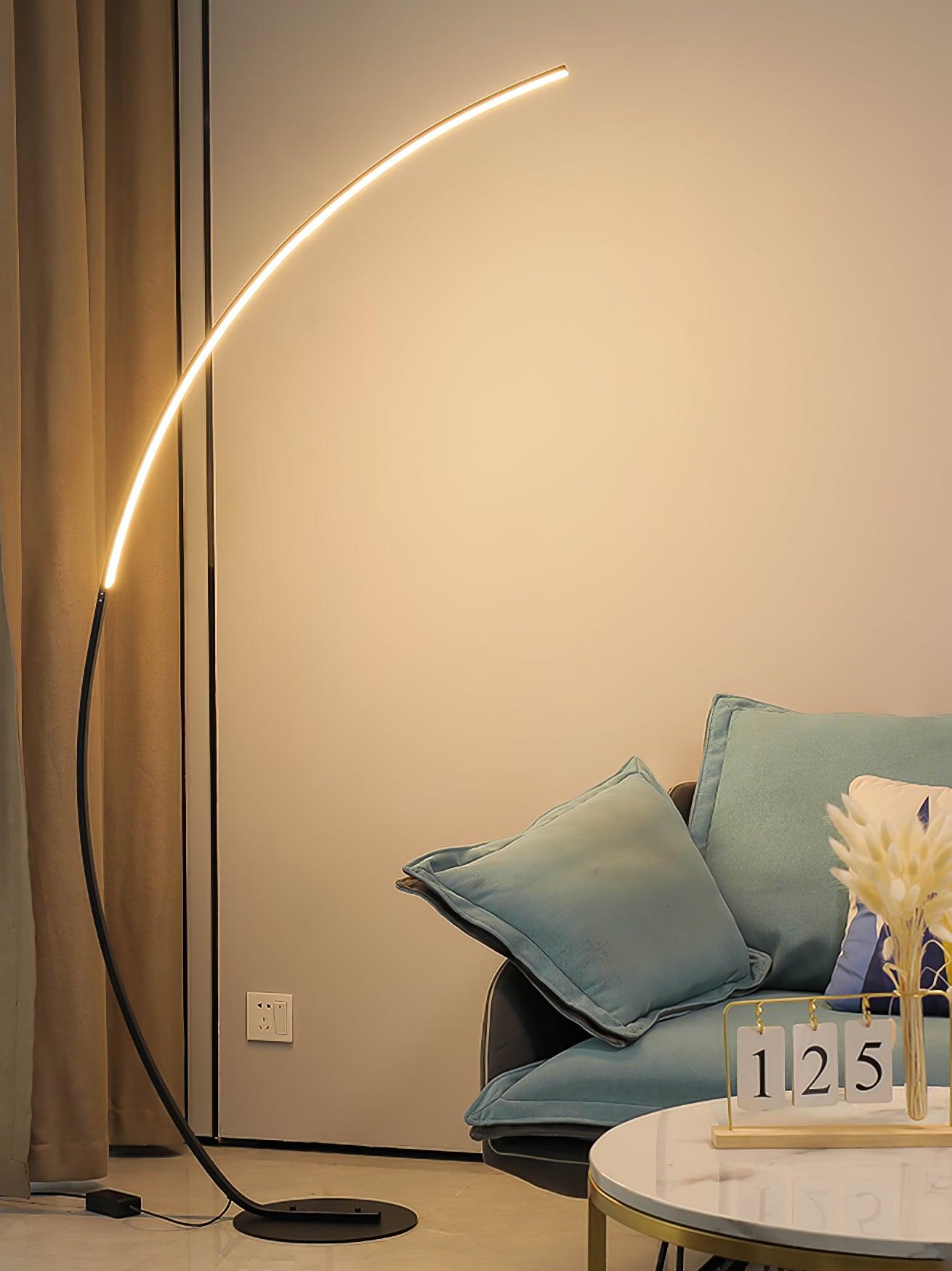 Black arc lamp beside turquoise sofa