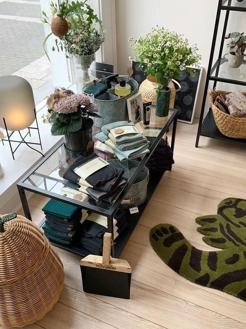 Small glass lamp in a room with mirrored furniture and floral arrangements.
