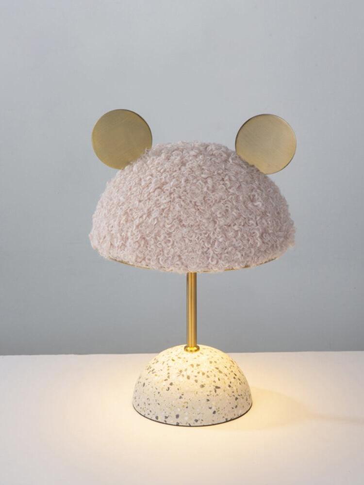 Pale pink plush shade lamp with illuminated tabletop near terrazzo base