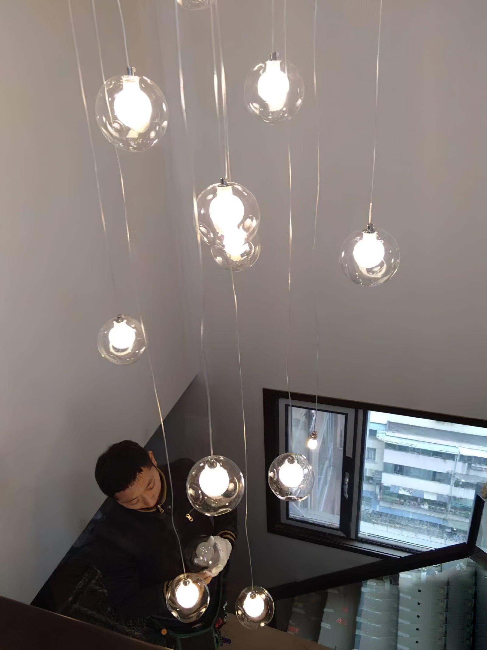 Staggered globe pendants over a stairway