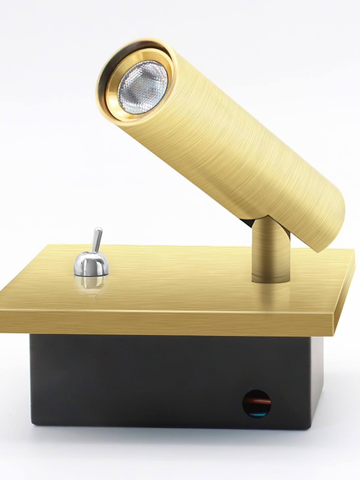 Enna gold-tone side view showing textured round lens, stem joint, silver toggle and dark rear housing with cable-entry hole