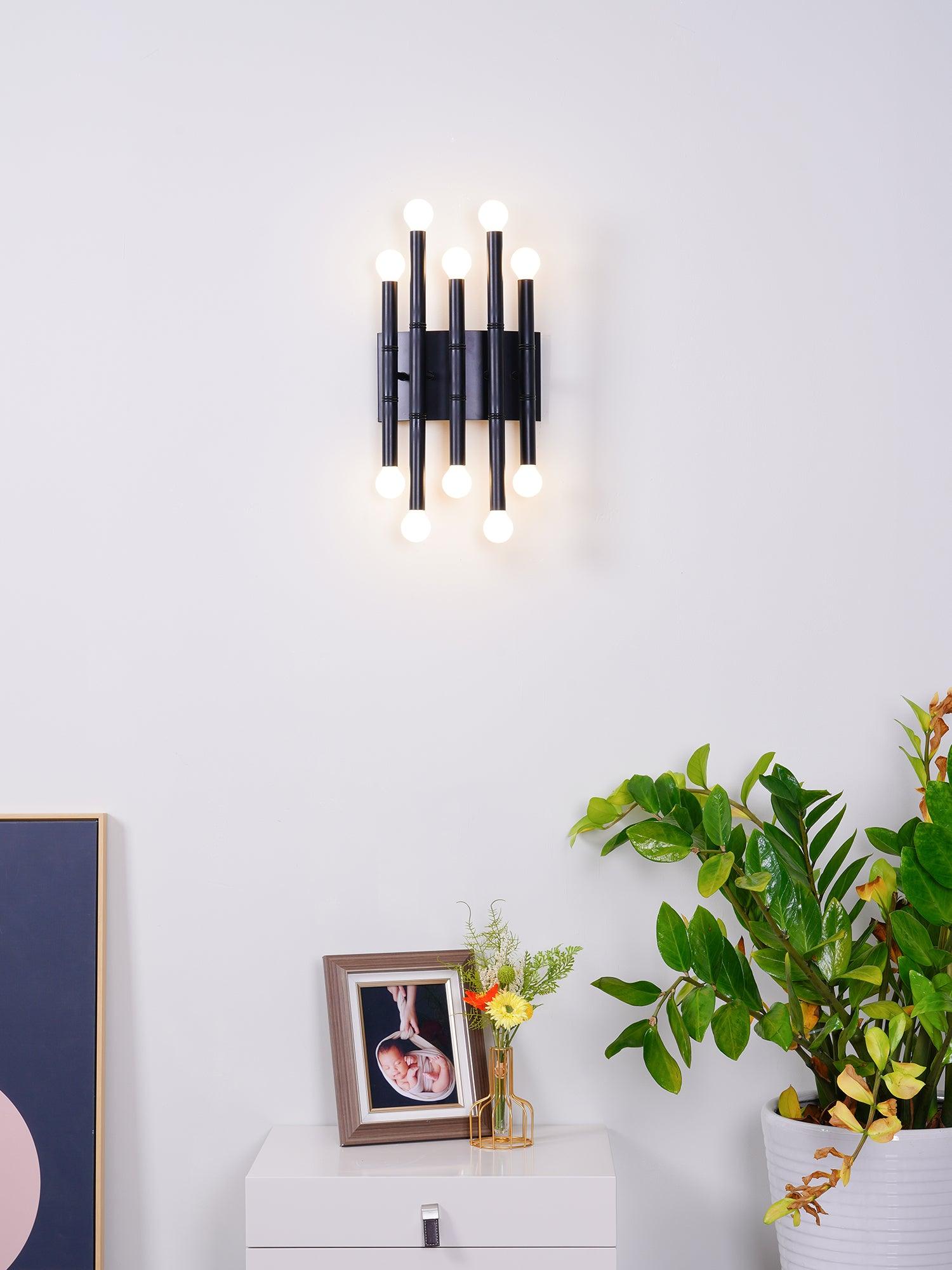 Black Meurice seen from the front, with ten glowing globe bulbs above a white cabinet and plants