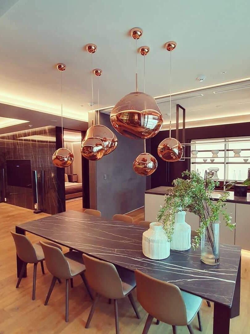 Metallic-looking pendants above a wood dining table