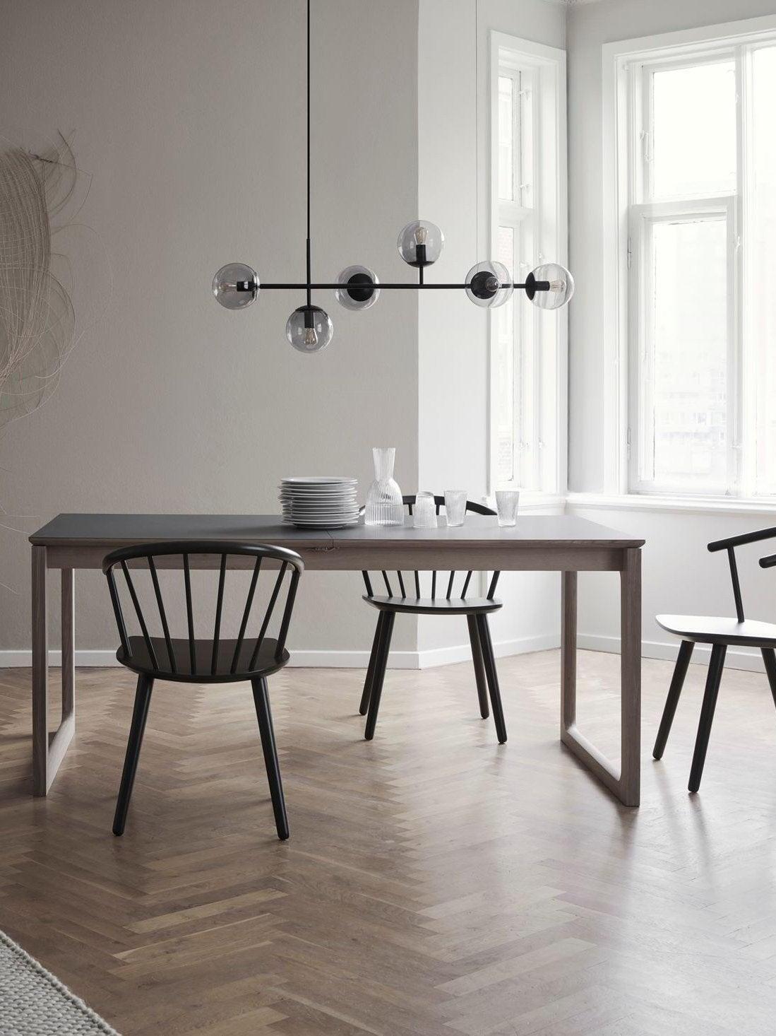 Black Orb chandelier above a dining table by a window