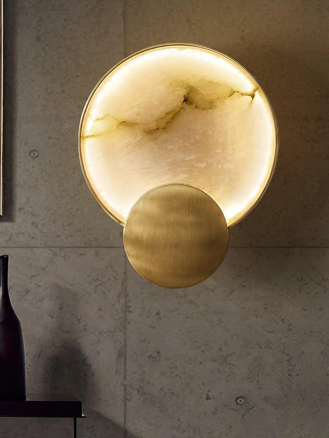 Lit veined alabaster circle on a grey wall