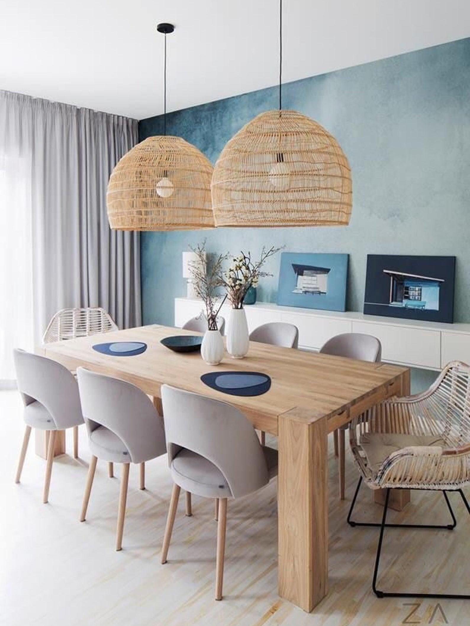 Paired natural wicker pendants over a dining table