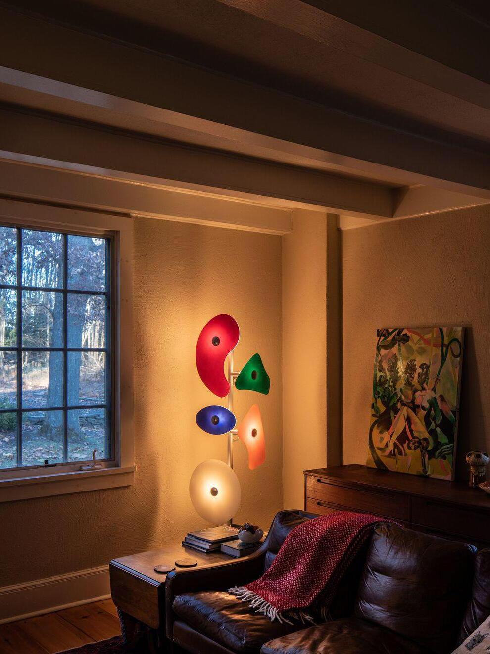 Multicolour floor lamp beside an armchair at night
