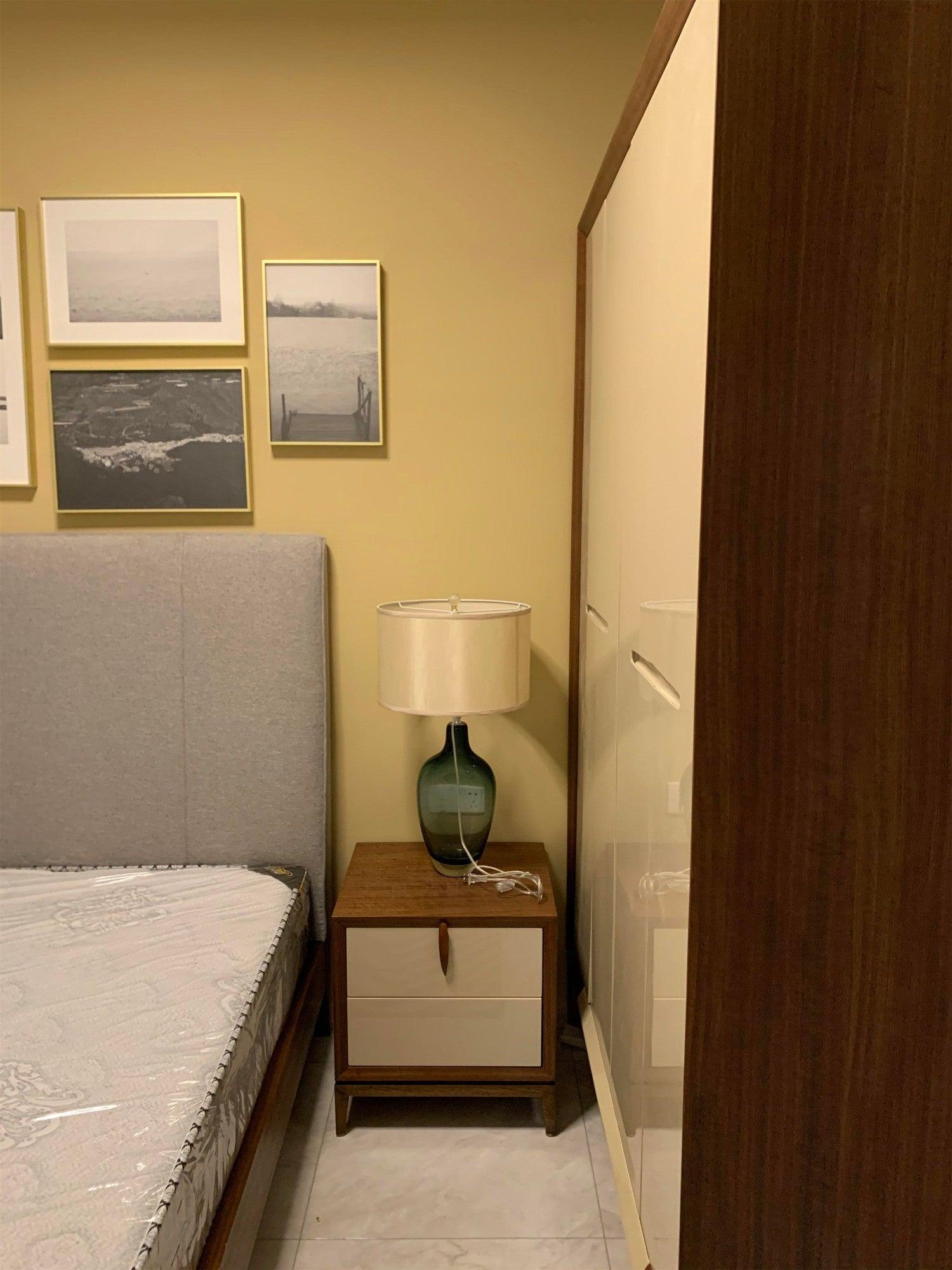 Bedroom view with rounded-base lamp on bedside cabinet
