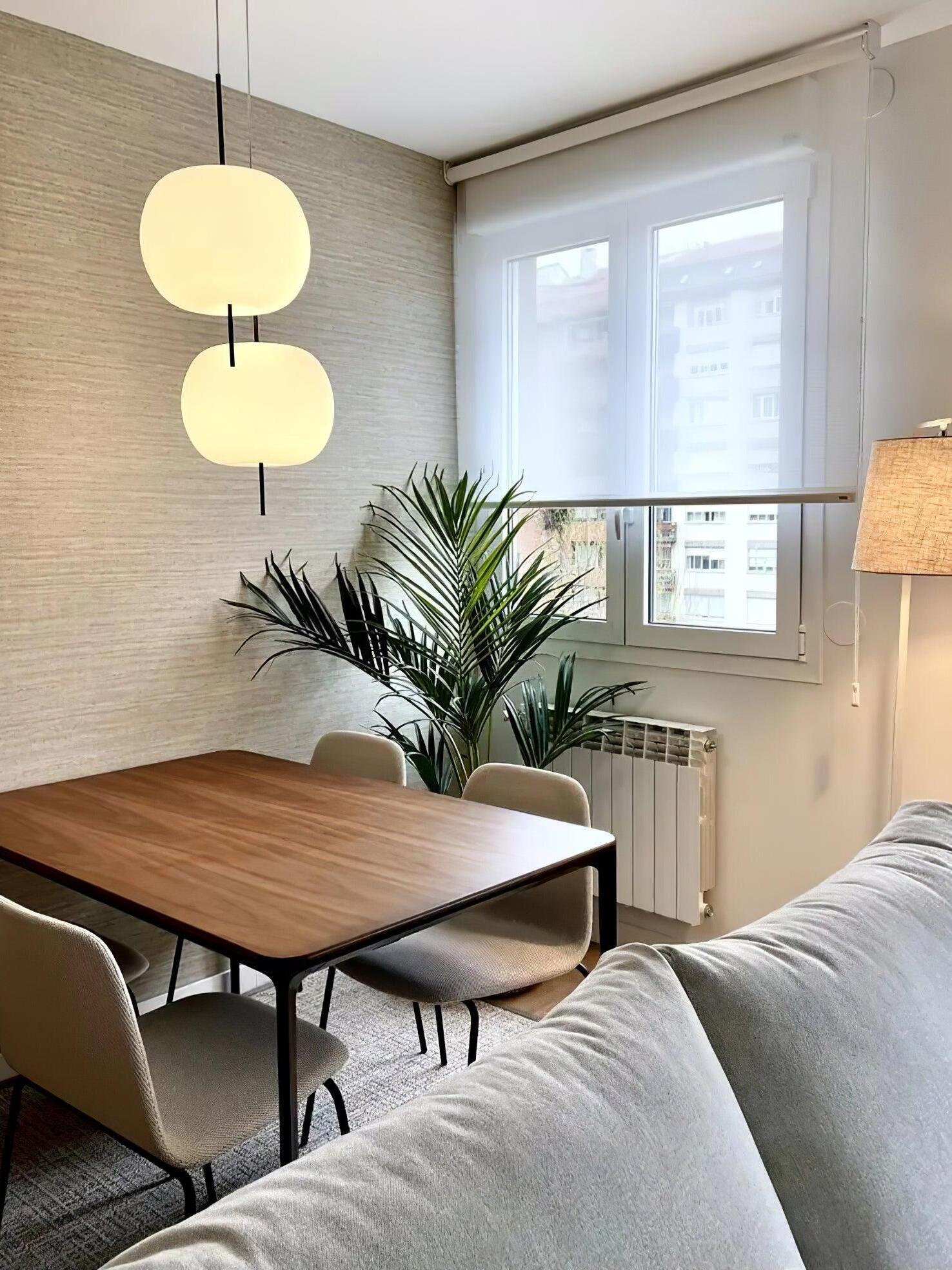 Two white pendants above a wooden dining table