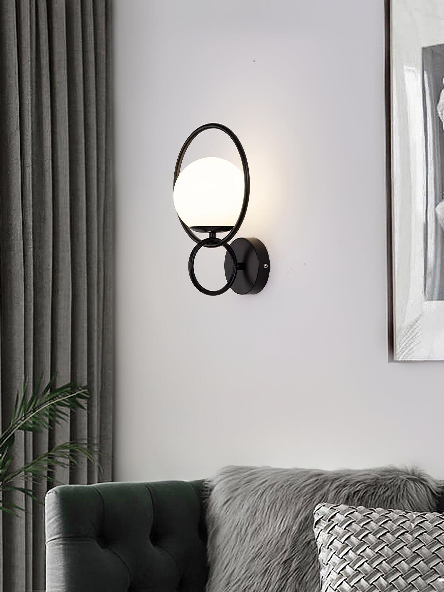 Black ringed white globe wall light above sofa