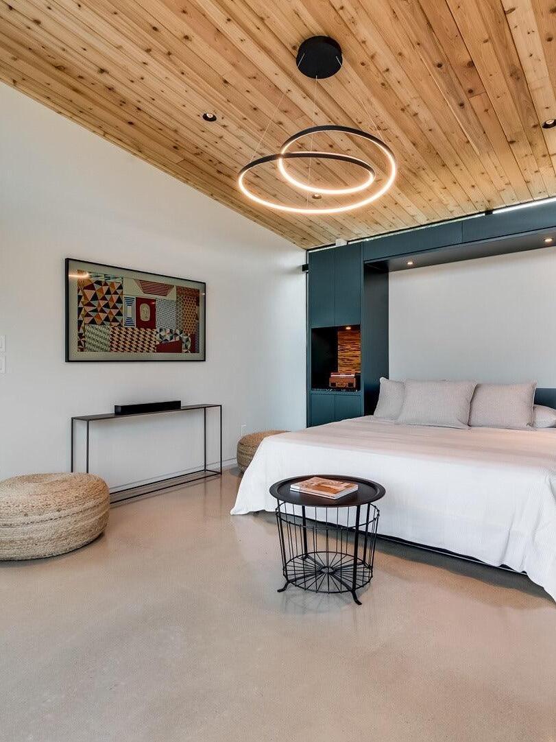 Looping pendant fixture above a bedroom area