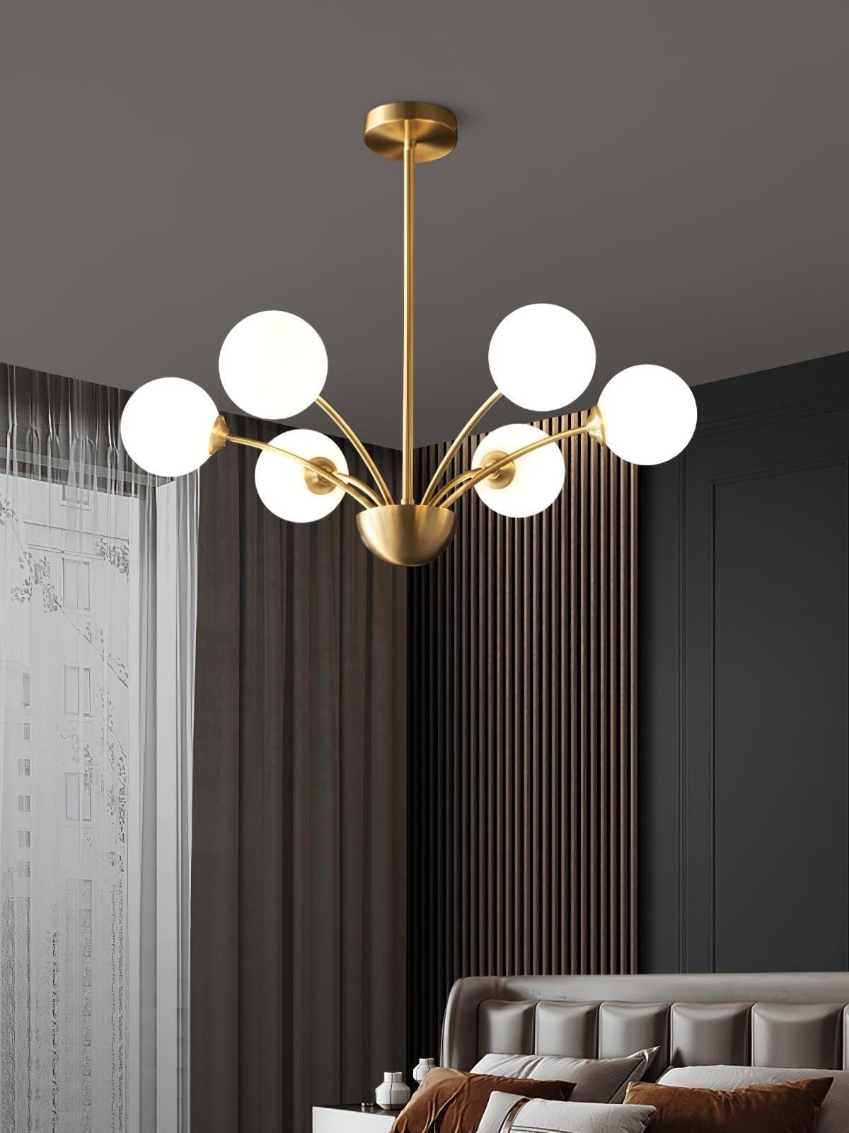 Six white globes on curved brass-tone arms above an upholstered bed beside a slatted wall and window