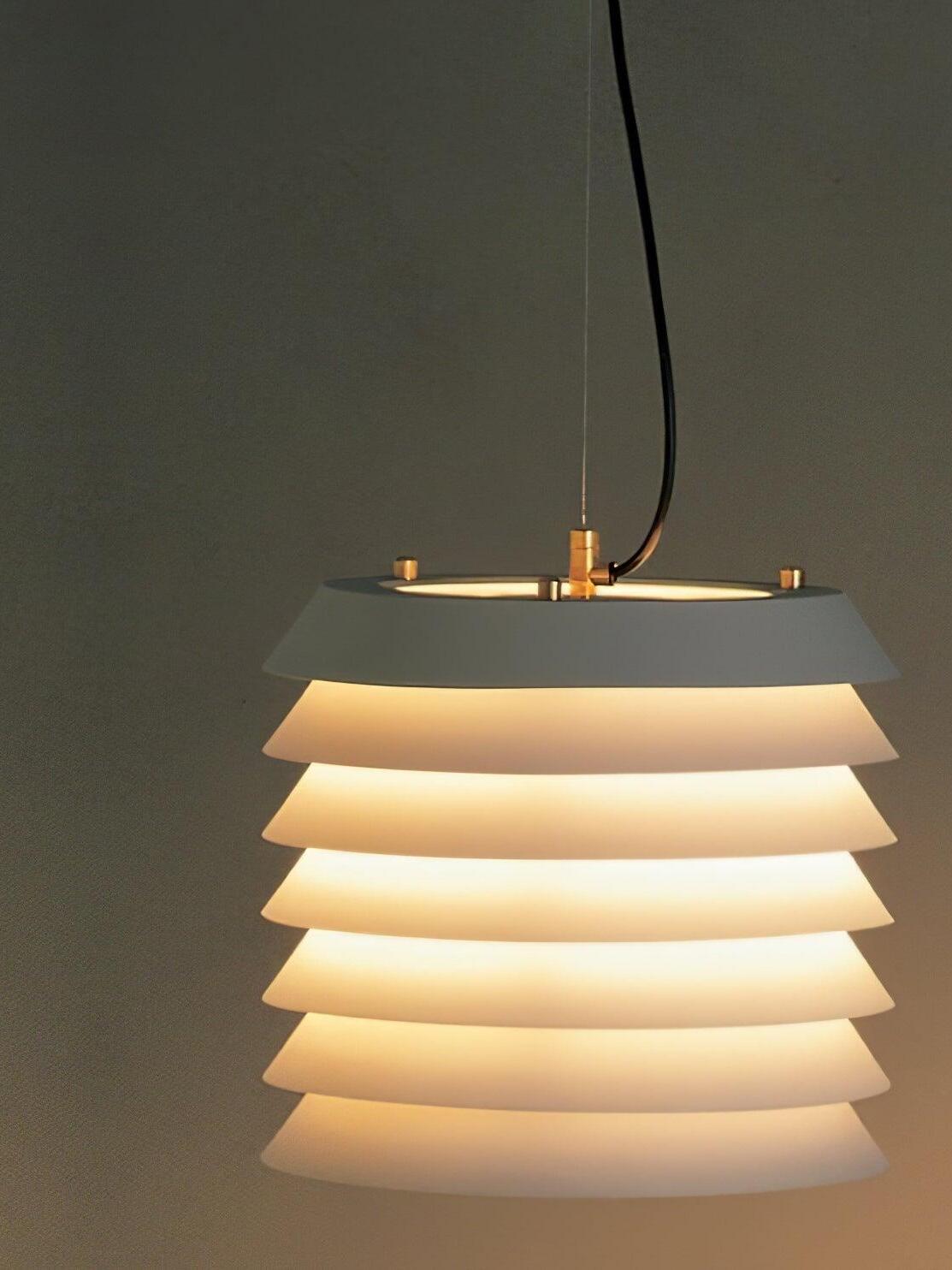 Close lit white layered shade with glowing gaps between plates