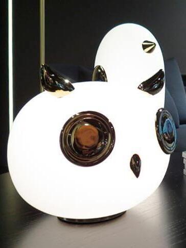 Close lit owl with reflective eye discs and penguin behind