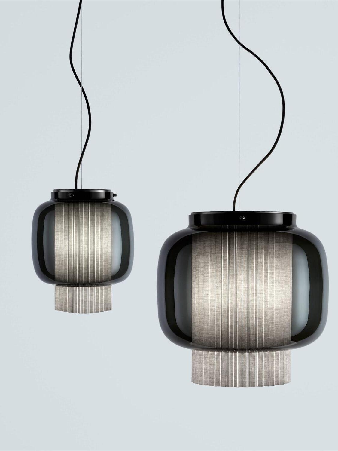Two different-size Black and smoke-grey Manila T pendants with grey pleated diffusers against pale blue-grey