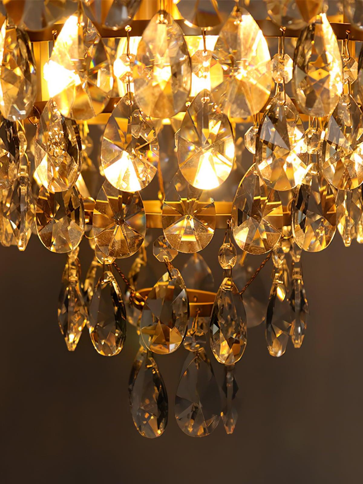 Close view of lit teardrop-shaped crystal pieces and small faceted links on a chandelier