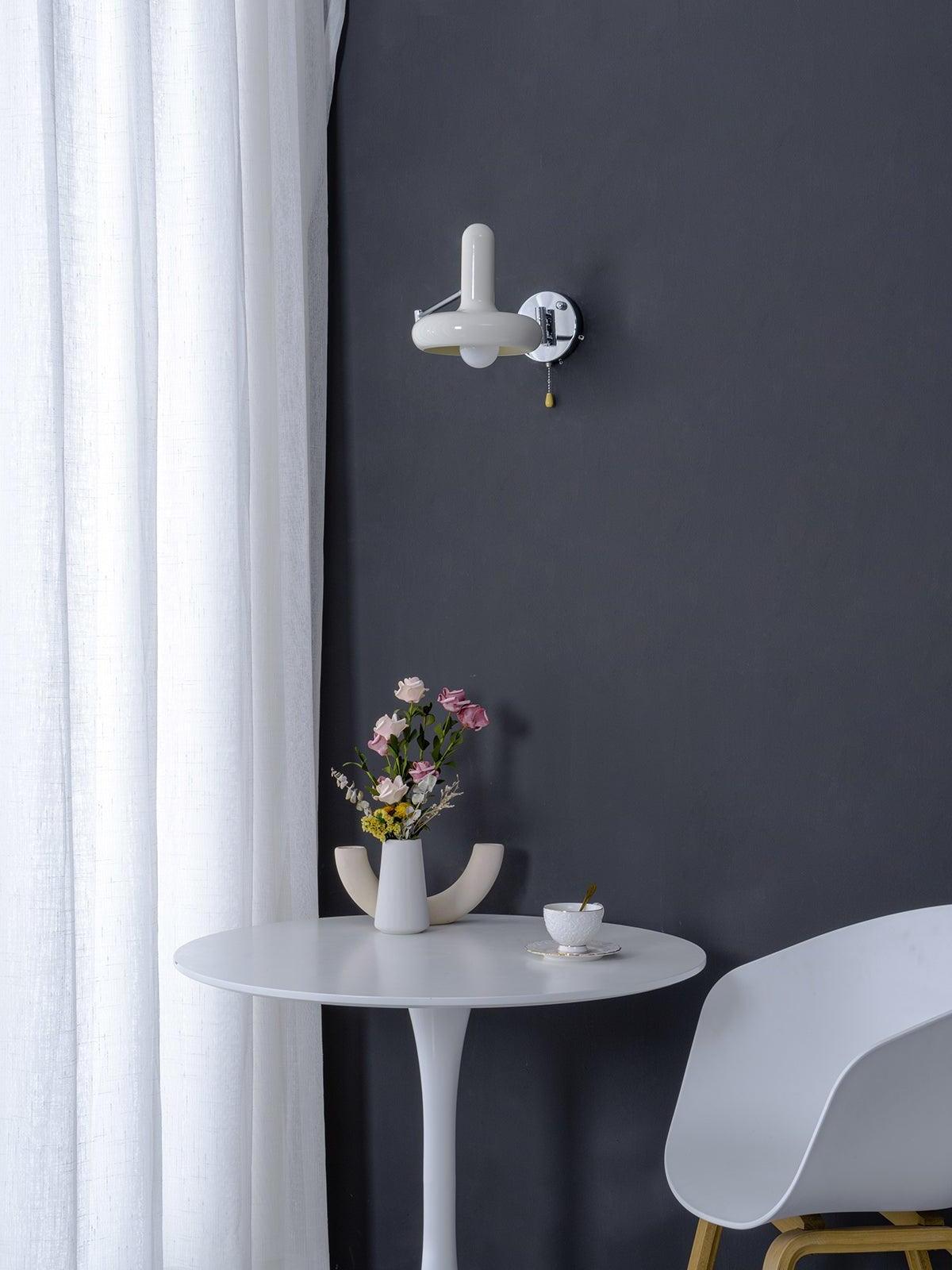 Unlit cream wall light above white round table