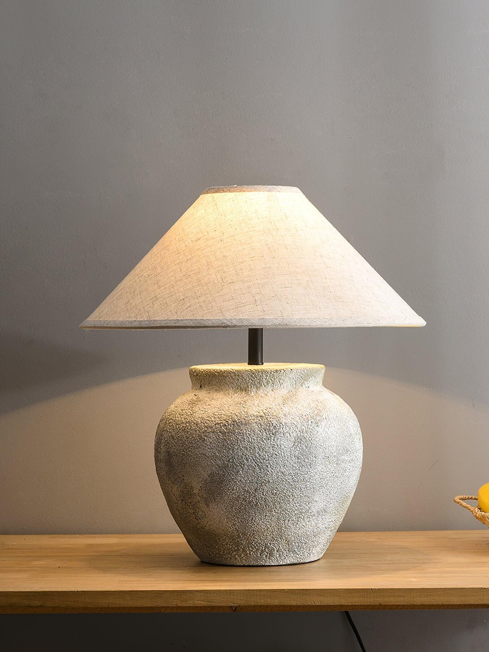 Glowing urn lamp on wood sideboard