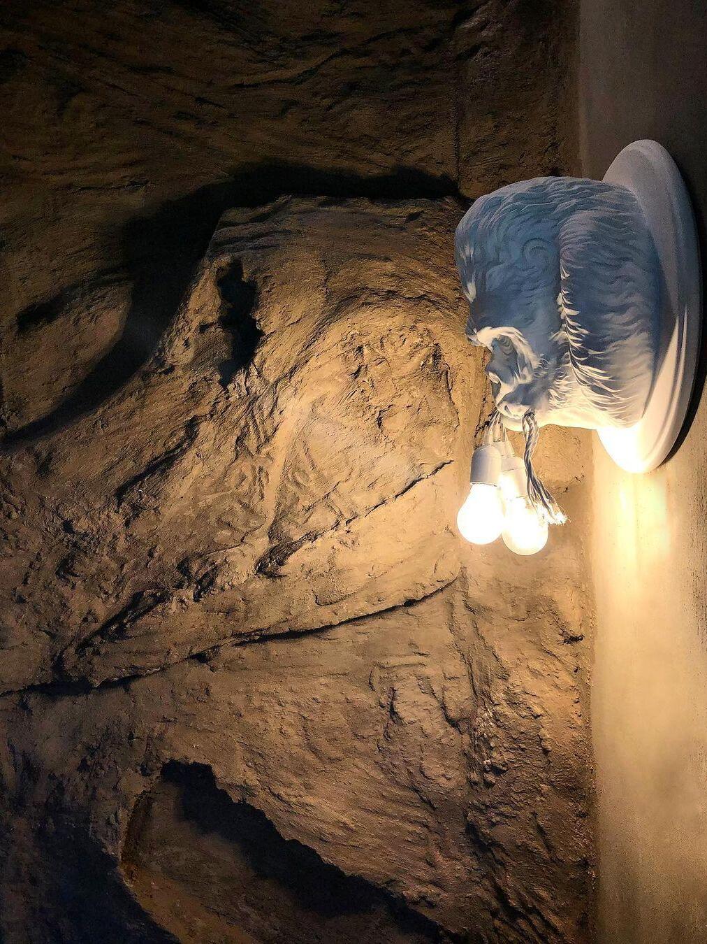 White gorilla profile and glowing bulbs against rough rock wall