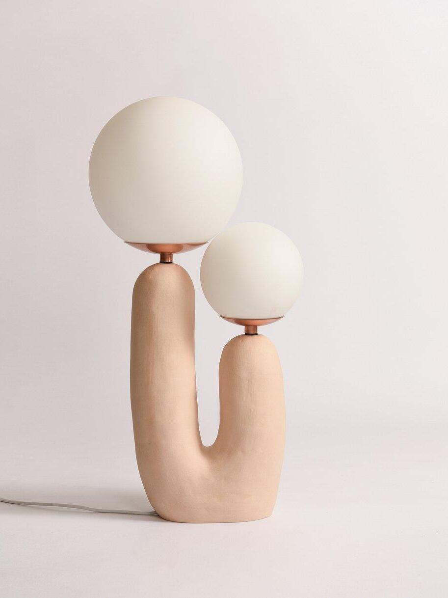 Beige-toned U-shaped lamp with unequal opal globes
