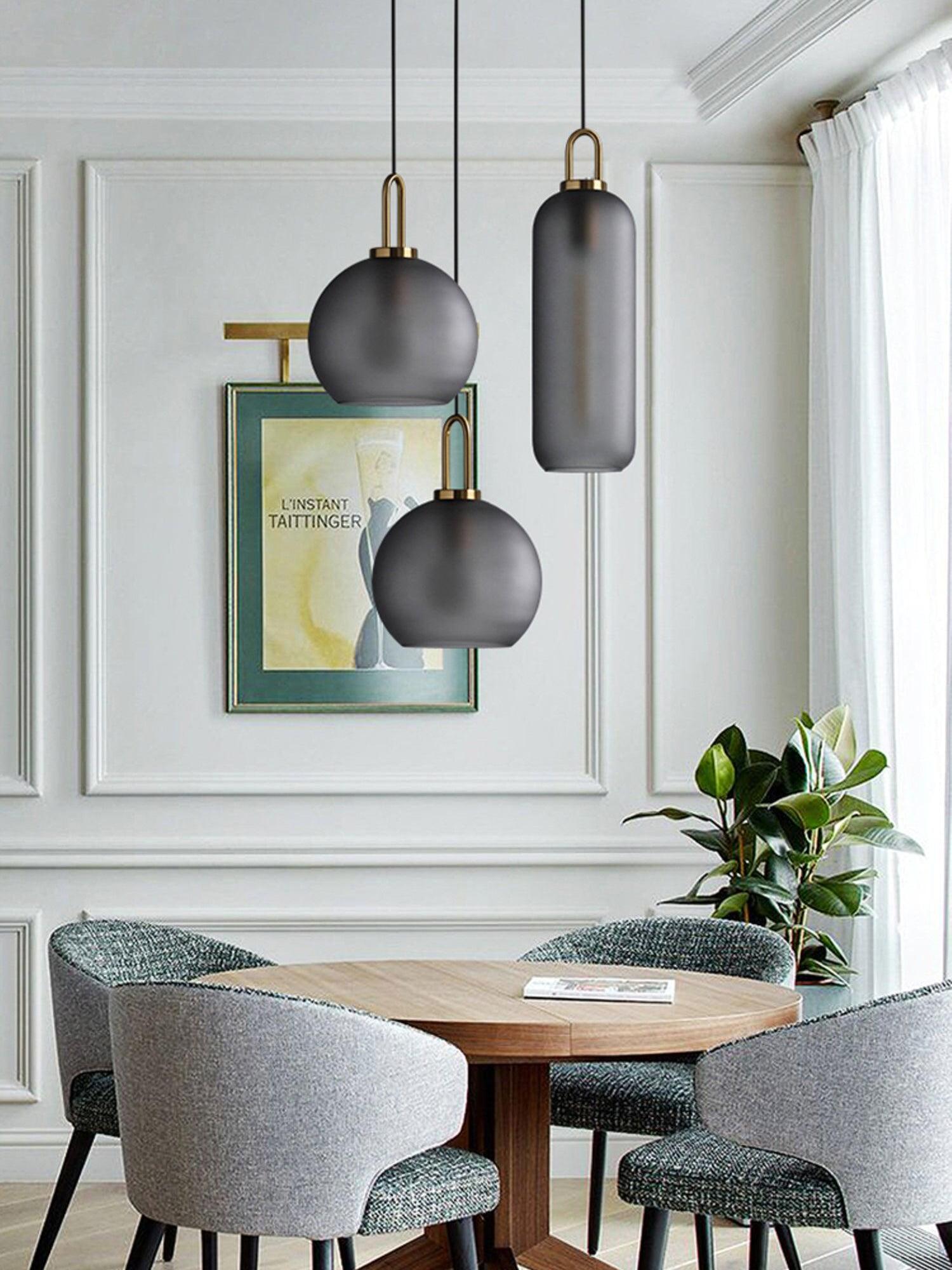 Frosted capsule and sphere pendants above a dining table