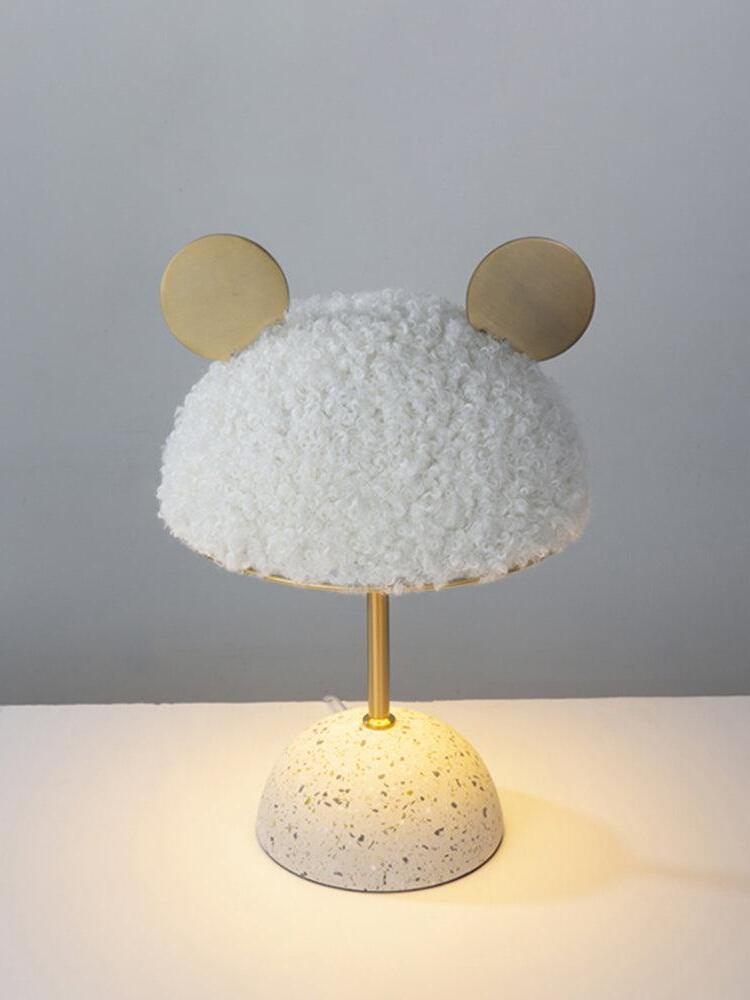 White plush shade lamp with illuminated area around pale base on tabletop